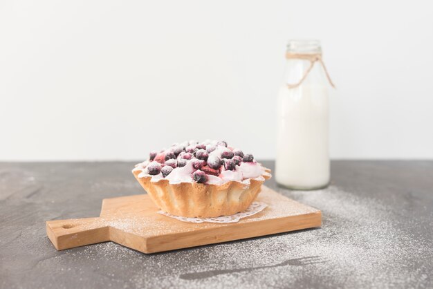 Homemade delicious blueberries tart on chopping board with milk bottle