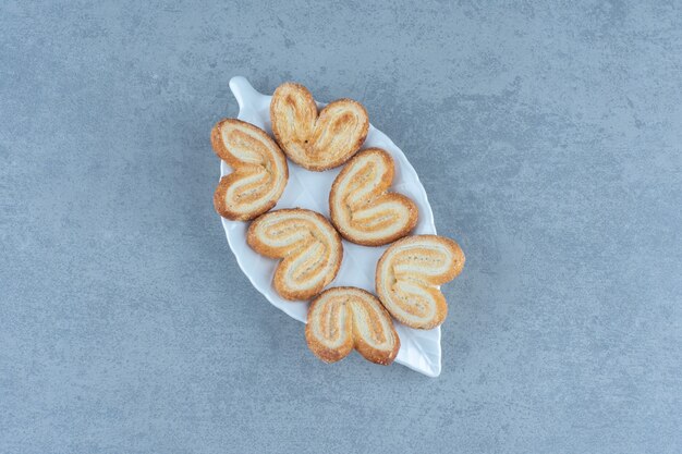 Homemade delicious cookies on white plate over grey table.