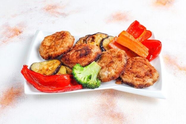 Homemade delicious cutlets with roasted vegetables.