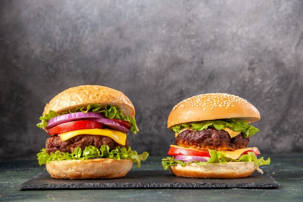 Homemade delicious sandwiches on black board on gray blurred surface