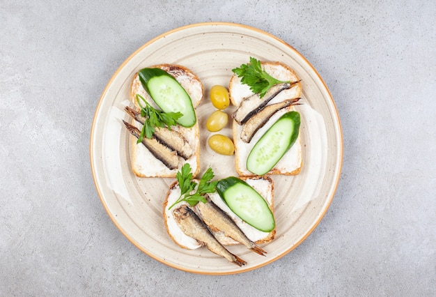 Free photo homemade fish sandwiches on plate over grey surface.