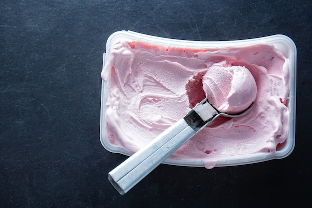 Бесплатное фото Домашнее фруктово-ягодное мороженое с ложкой для мороженого в контейнере.