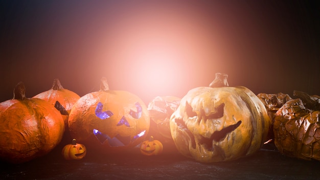 Homemade Halloween pumpkins with angry carved faces and light behind