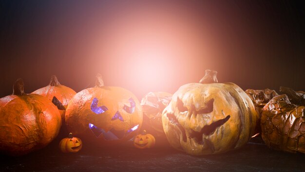 Домашние тыквы Хэллоуина с разгневанными резными лицами и светом позади