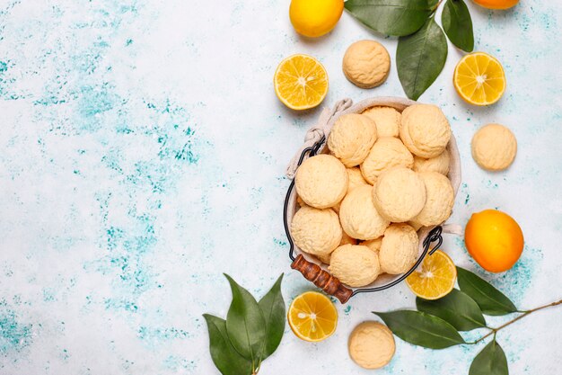 Homemade lemon cookies with lemons on light surface