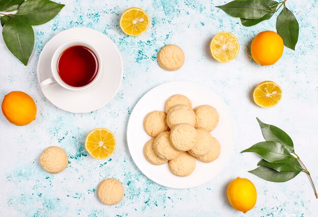 Homemade lemon cookies with lemons on light surface