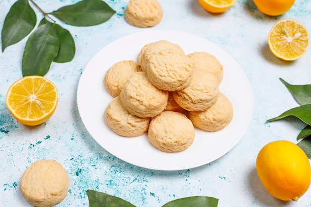 Homemade lemon cookies with lemons on light surface