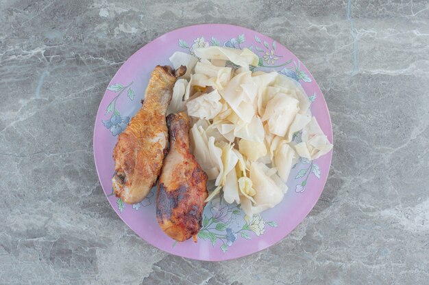 Homemade lunch. Grilled chicken drumsticks and cabbage pickle . 