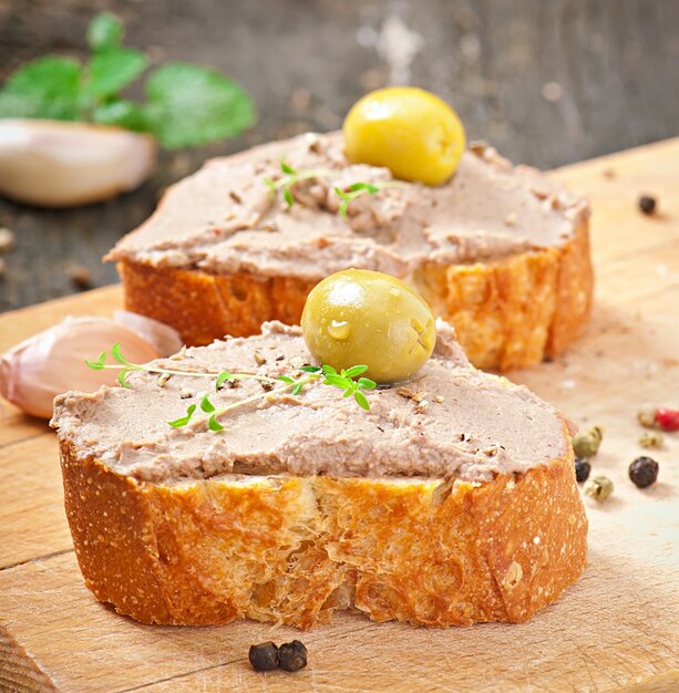 Homemade meat snack chicken liver pate with savory and olives