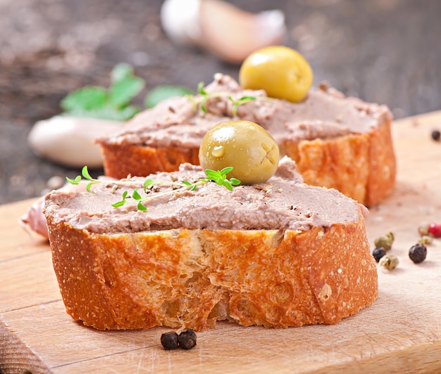 Homemade meat snack chicken liver pate with savory and olives