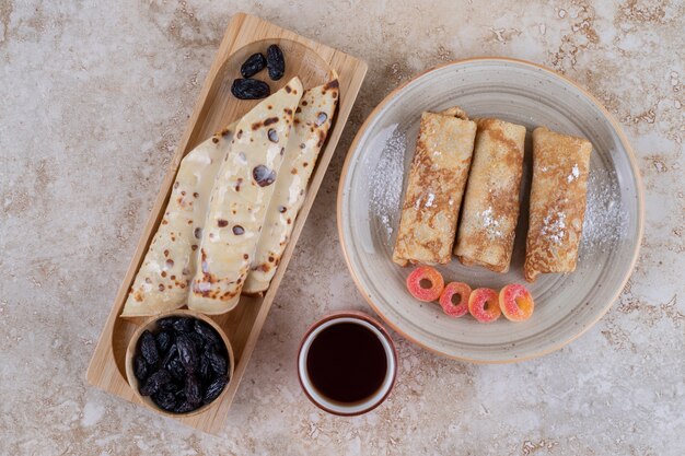 Homemade pancakes roll with raisin and sugar powder