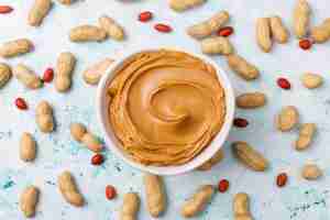 Free photo homemade peanut butter with peanuts on grey concrete table, top view