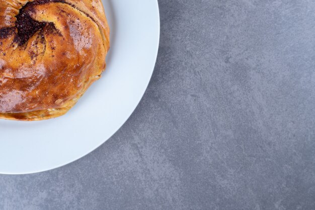 Homemade pie on a plate on marble table.