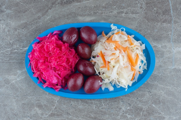 Free photo homemade pile of sauerkraut on blue wooden plate