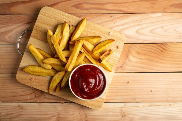 Homemade potato fries on wooden table