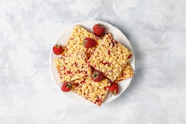 Homemade raspberry crumble bar on plate on light 