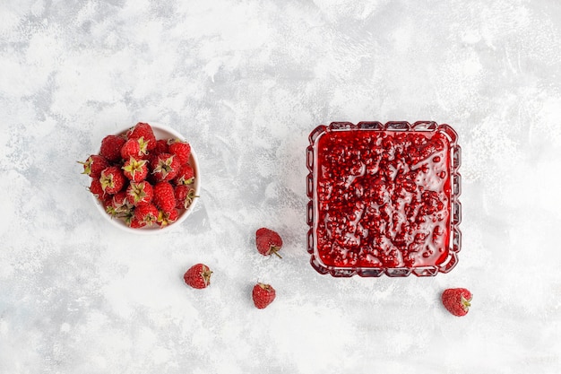 Free photo homemade raspberry jam with fresh raspberries on concrete , top view