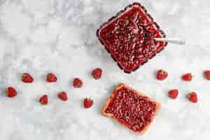 Free photo homemade raspberry jam with fresh raspberries on concrete , top view