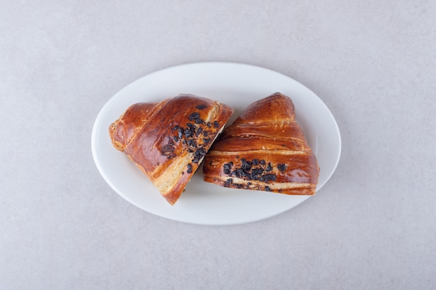 Croissant a fette fatto in casa con cioccolato su un piatto, sul marmo.