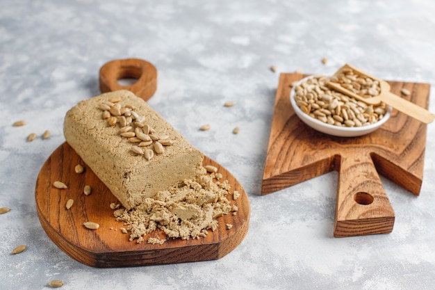 Homemade sunflower halva on cutting board with sunflower seeds