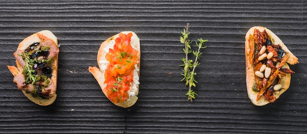 Homemade toast sandwiches with thyme on wooden black background
