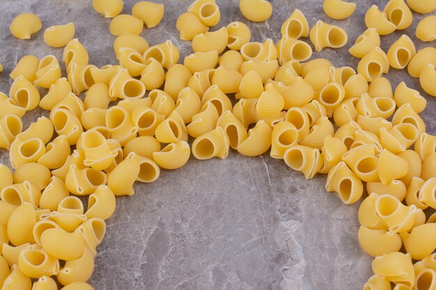 Homemade uncooked pastas isolated on the marble surface