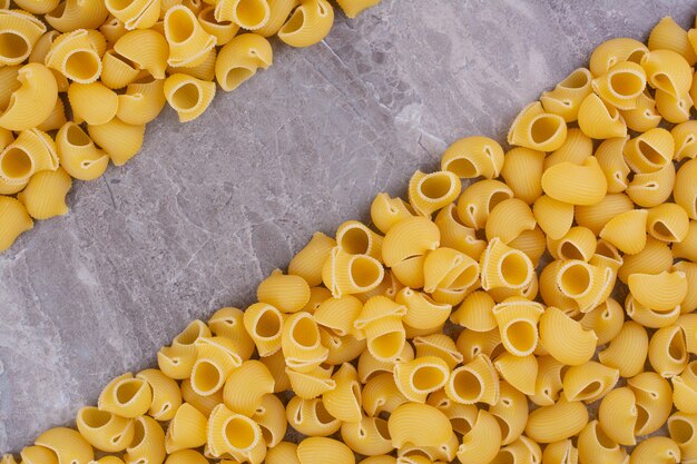 Homemade uncooked pastas isolated on the marble surface