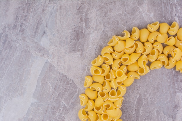 Homemade uncooked pastas isolated on the marble surface