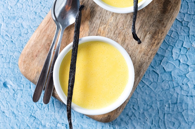 Homemade vanilla custard on blue background