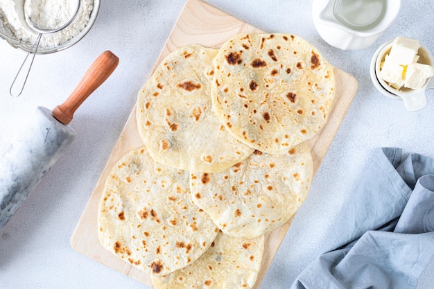 Homemade wheat tortillas pita bread tortilla pita with ingredients for cooking on a white table Top view