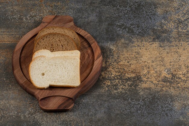 Homemade white and black bread on wooden board