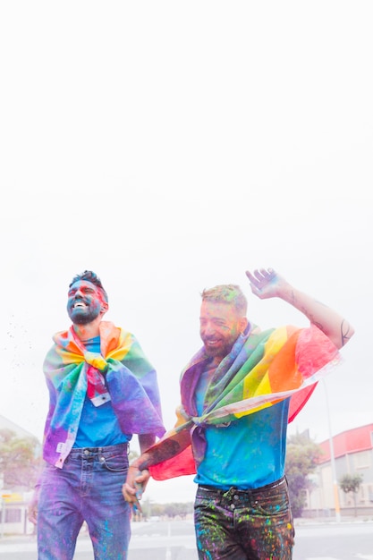 Homosexual couple in colorful powder having fun on parade