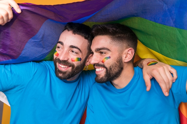 Foto gratuita coppia omosessuale di uomini che si abbracciano sulla bandiera lgbt