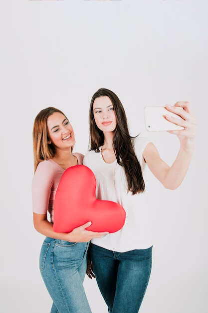 Foto gratuita coppia omosessuale prendendo selfie con cuore rosso