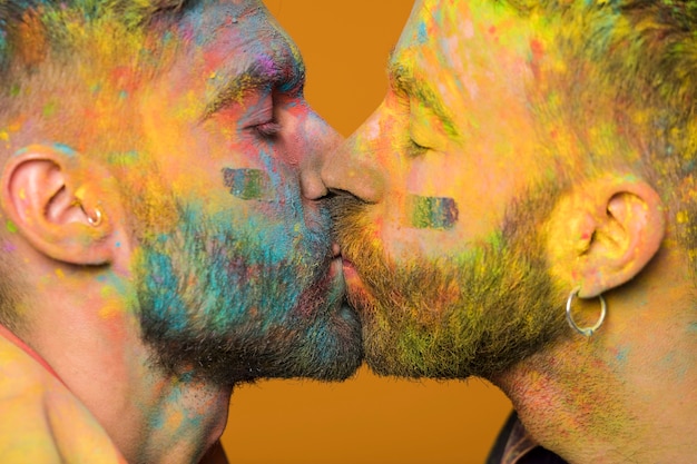 Homosexual sweethearts kissing soiled in paint