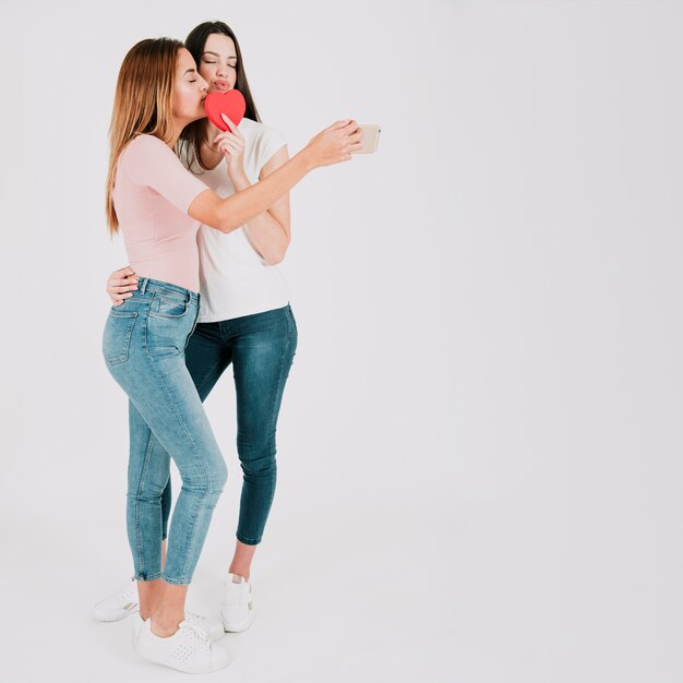 Homosexual women taking selfie with heart