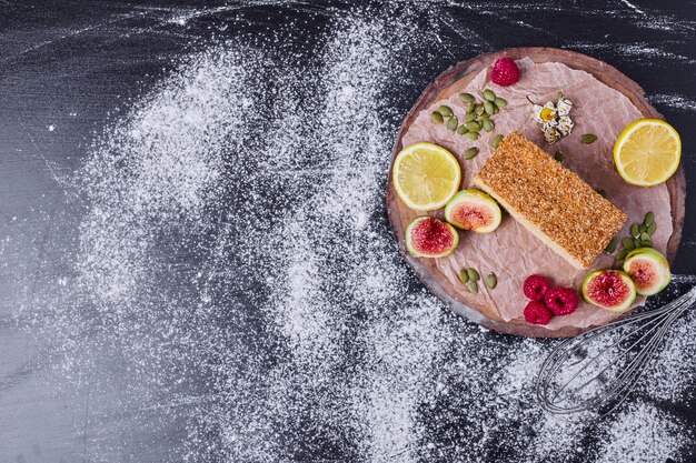 Honey cake and figs on round wooden platter. 