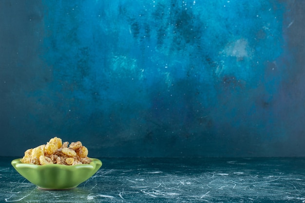 Honey corn ring with muesli in a bowl , on the blue background. High quality photo