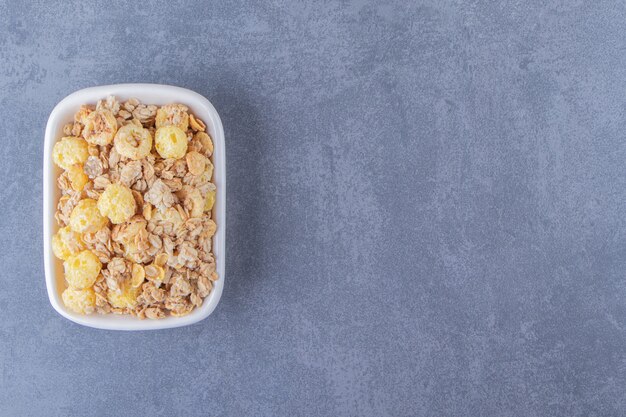 Honey corn ring with muesli in a bowl , on the marble background.