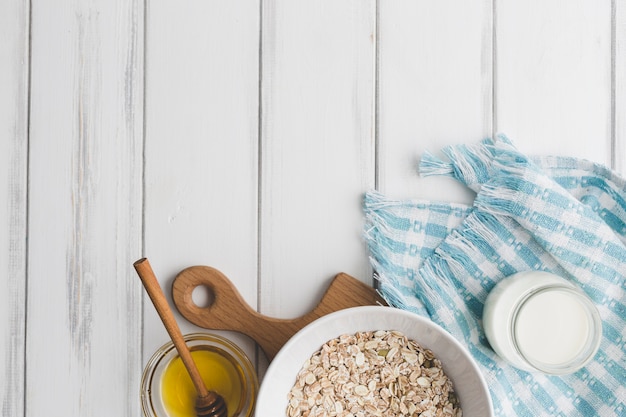 Foto gratuita miele e prodotti lattiero-caseari vicino alla farina d'avena