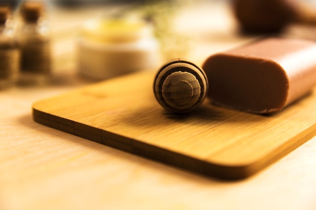 Honey dipper and herbal soap on wooden board