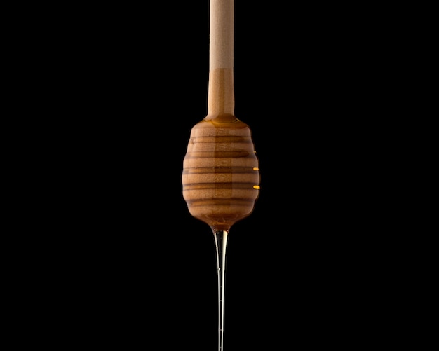 Free photo honey dipper with liquid honey, close-up. kitchen utensil