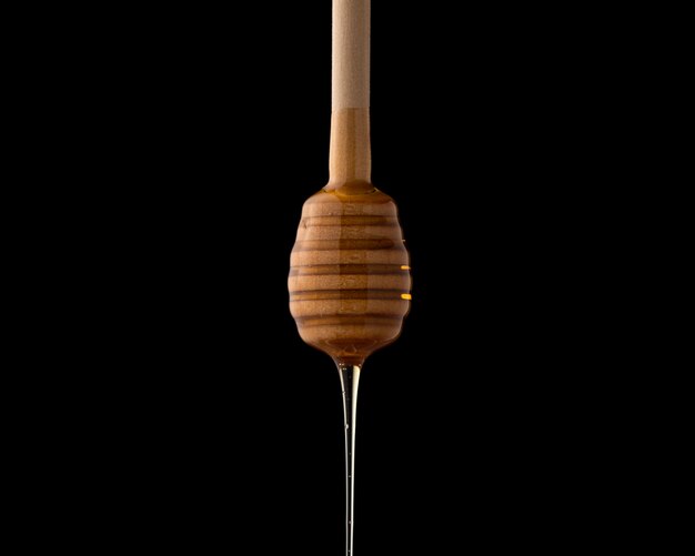 Honey dipper with liquid honey, close-up. Kitchen utensil