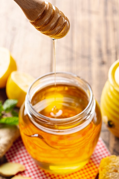 Honey dripping from dipper in jar