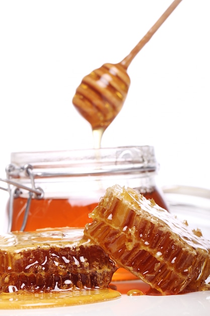 Foto gratuita miele gocciolante da un cucchiaio di legno