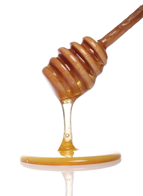 Honey dripping from a wooden spoon