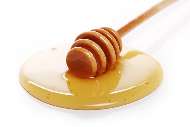 Honey dripping from a wooden spoon