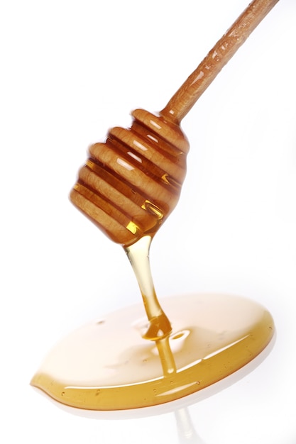 Honey dripping from a wooden spoon