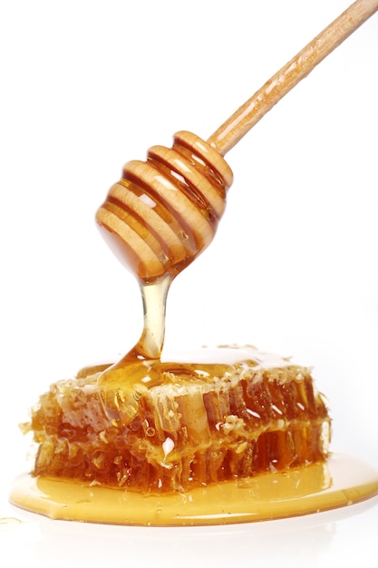 Free photo honey dripping from a wooden spoon