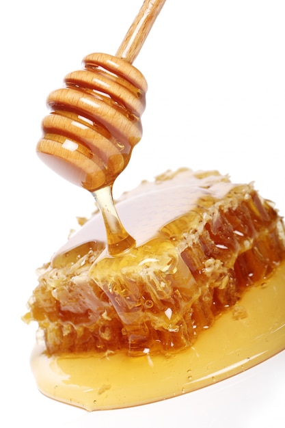 Free photo honey dripping from a wooden spoon